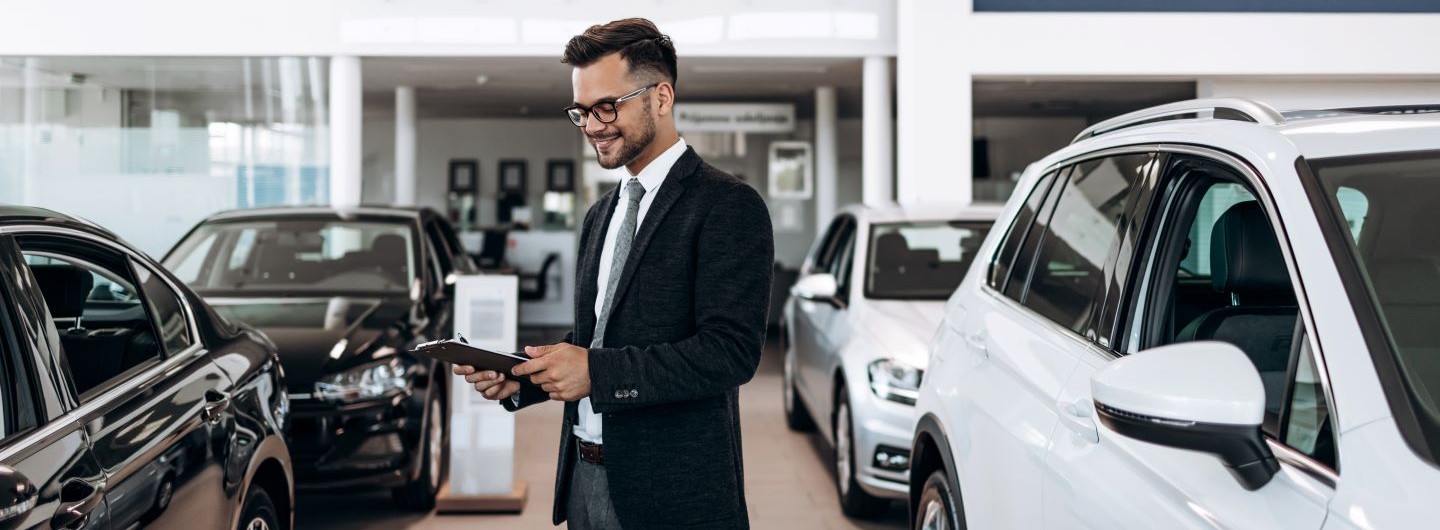 Mann aus Automobilwirtschaft mit Tablet in Autohaus