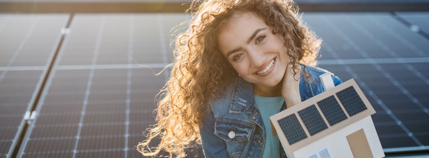 Energiewirtschaft Studium Frau hält Modelhaus mit Solarpanelen in der Hand