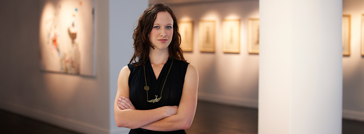 Kulturmanagement Studium: eine Frau steht in einer Kunstgalerie und guckt sich eine Ausstellung an.