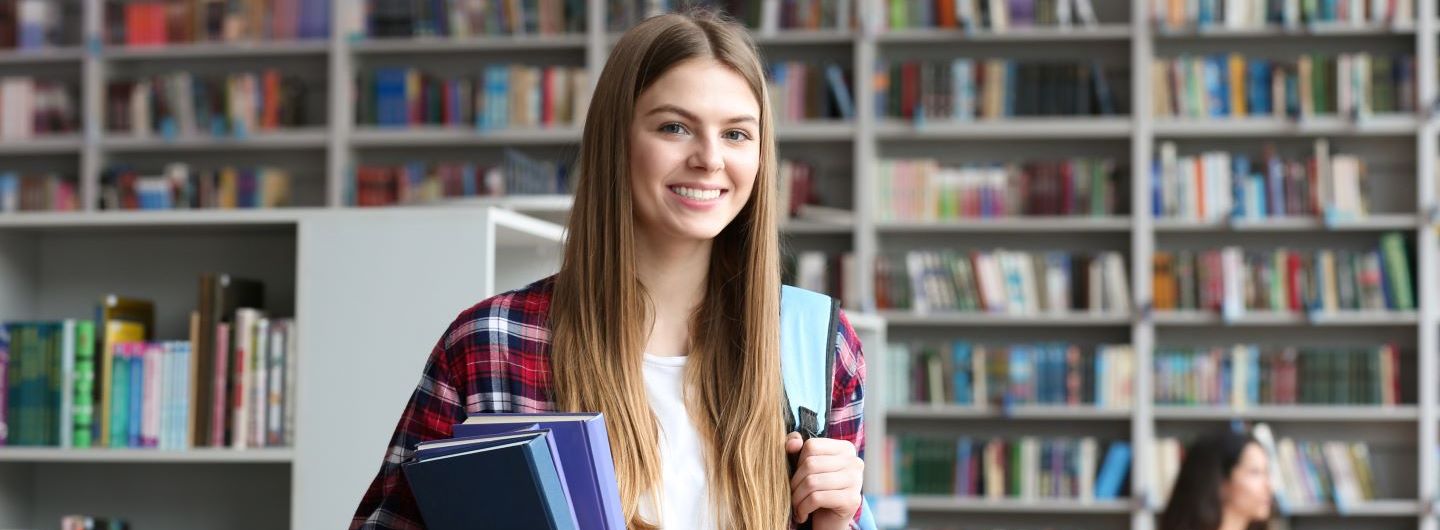 Literaturwissenschaft Studium: Junge Frau liest ein Buch in Bibliothek