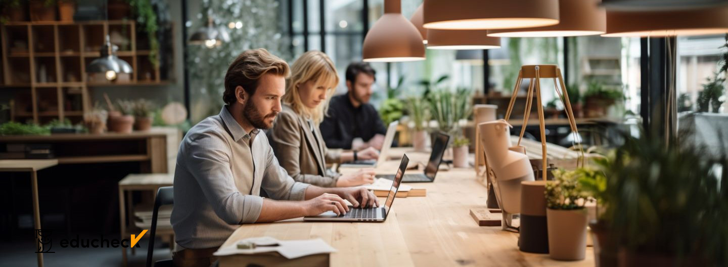 Nachhaltiges Design Studium: Nachhaltige Designer arbeiten in einem modernen Büro mit Holzmöbeln und Pflanzen an Laptops
