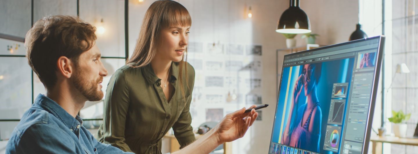Mann und Frau arbeiten am PC an Werbebild